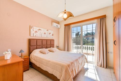 a bedroom with a bed and a large window at COLONIAL FAMILY apartment #3 in Faliraki