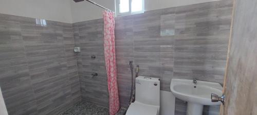 łazienka z toaletą i umywalką w obiekcie JCALM Beach resort w mieście Bulala