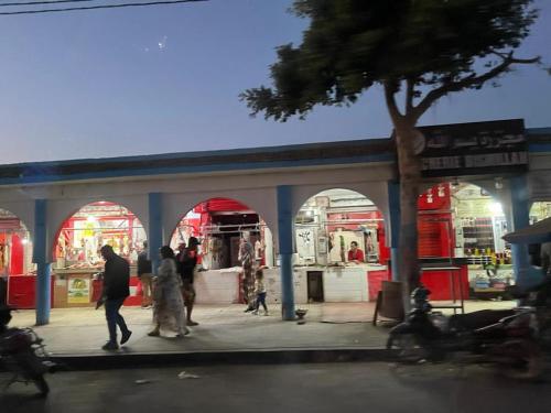 a group of people walking in front of a store at HOUSE l impérial pour vacance in Aourir