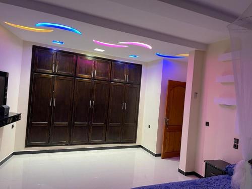 a large room with wooden cabinets and purple lights at HOUSE l impérial pour vacance in Aourir