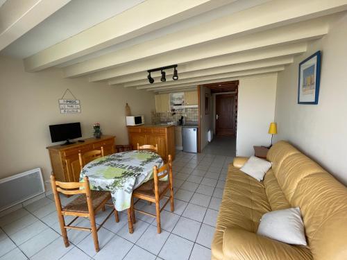 un salon avec un canapé et une table dans l'établissement L'Abri Côtier, à Mimizan