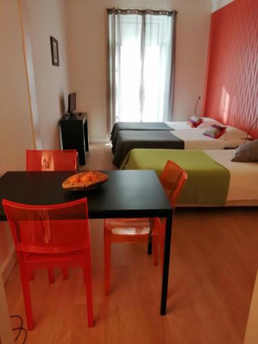 a room with two beds and a table and chairs at Evora Inn in Évora