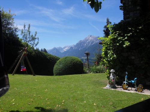 a childs bike parked in a yard with a mountain at Appartements Anfang in Weerberg