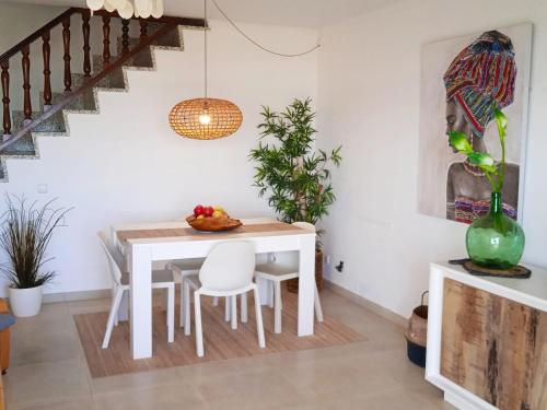 une salle à manger avec une table et des chaises blanches dans l'établissement Apt playa de Muro ca n Ines - 1ª linea de playa, à Port d'Alcúdia