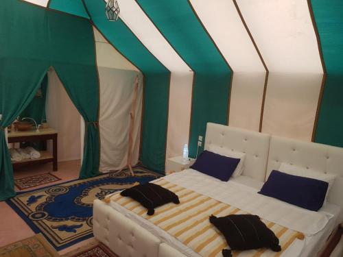 a bedroom with a bed in a tent at Merzouga-Bivouac-Excursion And Hosting in Merzouga