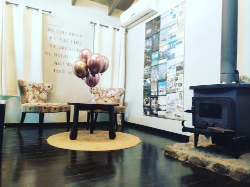 a room with a table with balloons and a stove at Vanilla Grey in Had Nes