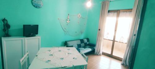 een blauwe kamer met een bed, een stoel en een raam bij Capitan Libeccio in Francavilla al Mare