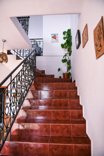a staircase in a house with wooden floors and white walls at Guest House Luli in Berat
