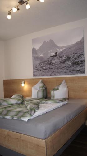 een bed in een kamer met een foto aan de muur bij Landhaus Zangerl - Kobelerhof in Landeck