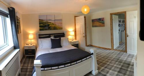 a bedroom with a bed and two lamps and a window at Old School - Exclusive 5 Room private suite in Orkney