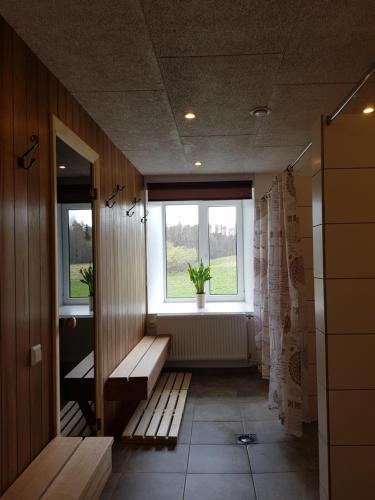 a hallway with benches and a window in a room at Viesu māja Vālodzes in Mārkalne