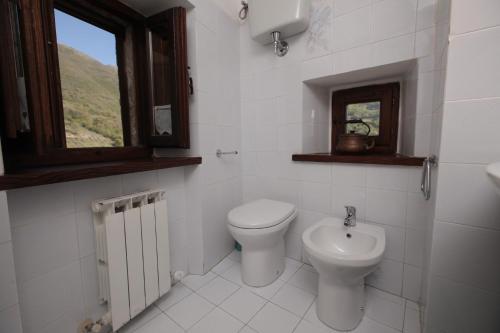baño con aseo y lavabo y ventana en Affittacamere Nonna Rosa, en Vallo di Nera