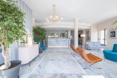 eine Lobby mit blauen Möbeln und einem Kronleuchter in der Unterkunft Hotel Luna in Marina di Massa