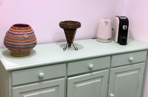 a white cabinet with two vases on top of it at ComfortHouse Ladispoli in Ladispoli