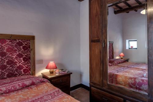 a bedroom with two beds and a large mirror at Agriturismo Tenuta Di Mensanello in Colle Val D'Elsa