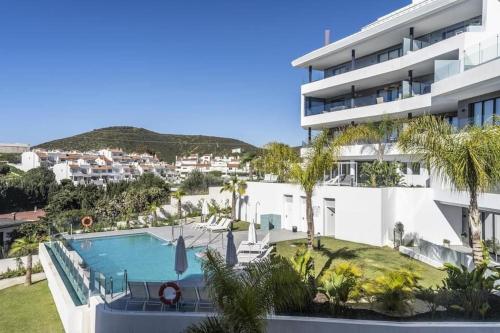 duży budynek z basenem i palmami w obiekcie Luxury Apartment Fernando - The View Fuengirola w mieście Fuengirola