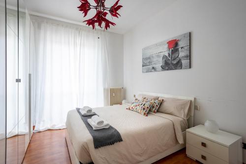 a white bedroom with a bed and a chandelier at Suite 17 Monza centro,Milano centro,netflix in Monza