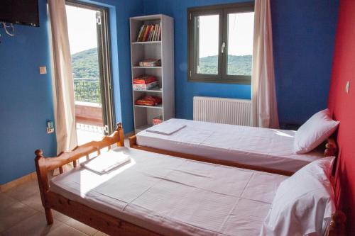 a bedroom with two beds and a book shelf at Villa Tzanatos in Troïanáta