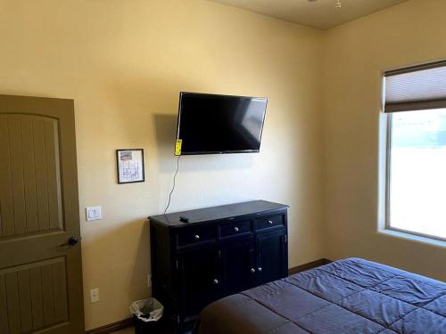 a bedroom with a bed and a flat screen tv on the wall at Spacious Home in Page