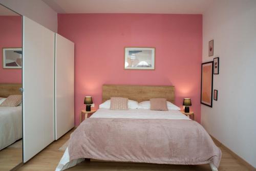 a bedroom with pink walls and a large bed at Studio apartman Rossa in Daruvar