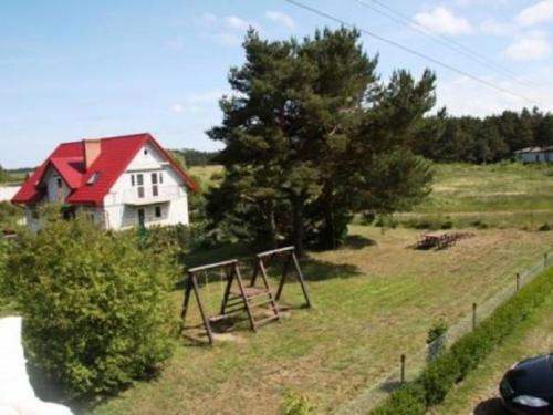 a yard with a swing set and a house at Nella - Pokoje gościnne in Ostrowo