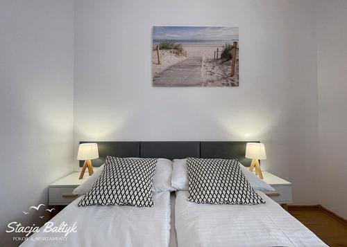 1 dormitorio con 2 camas y una foto de la playa en Stacja Bałtyk, en Karwia