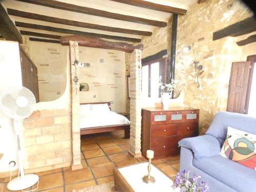 a living room with a blue couch and a bedroom at No 2 Spacious and Airy Apartment in Javea Medieval Village in Jávea