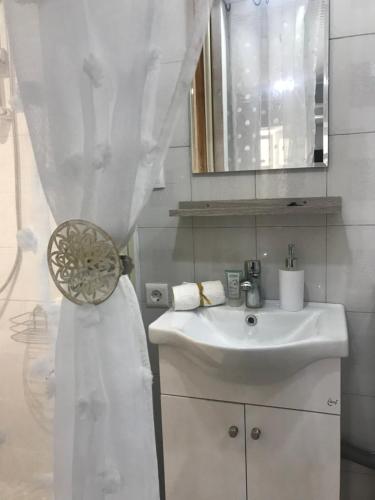 a white bathroom with a sink and a mirror at Central Park in Corfu