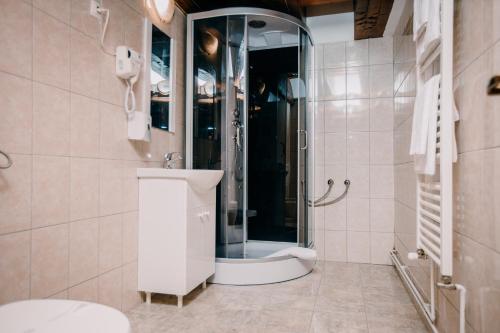 a bathroom with a shower and a toilet and a sink at Pensiune și Camping Patru - Gheorgheni in Gheorgheni