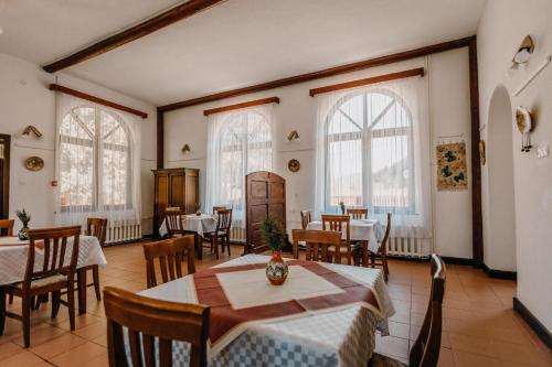 a dining room with tables and chairs and windows at Pensiune și Camping Patru - Gheorgheni in Gheorgheni