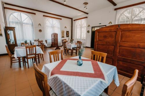 a dining room with tables and chairs and windows at Pensiune și Camping Patru - Gheorgheni in Gheorgheni