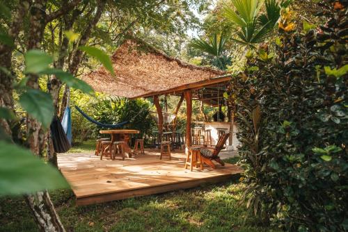 eine Holzterrasse mit einem Pavillon im Garten in der Unterkunft Passion Fruit Lodge in Cahuita