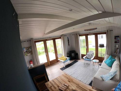 a living room with a white couch and chairs at Strandvakantiehuisje! in Workum