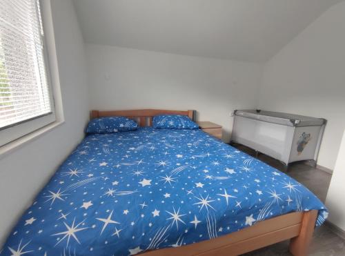 a bed with a blue comforter with stars on it at Apartman Amina-Ahmad Vinac-Jajce in Jajce