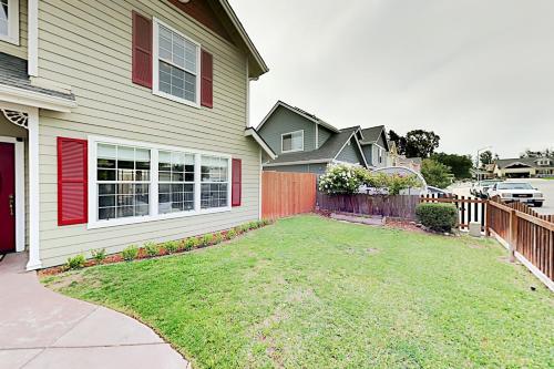 a house with a yard next to a fence at Victorian Dream in Arroyo Grande