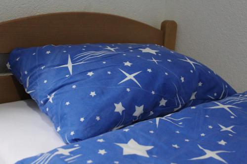 a blue pillow with white stars on a bed at Apartman Amina-Ahmad Vinac-Jajce in Jajce