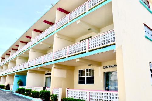 an exterior view of a building with pink balconies at Melrose Beach Apartments Inc in Bridgetown
