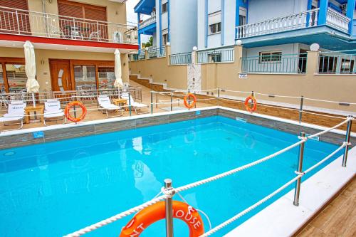 a swimming pool at a hotel with chairs and a building at RENT HOUSE ANEMOS in Iraklitsa