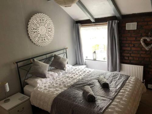 Un dormitorio con una cama con dos pares de zapatos. en Cosy Rustic 3 bed cottage, great train links en Bebington