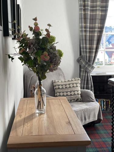 a vase of flowers sitting on a wooden table at The Upper Largo Hotel & Restaurant in Lundin Links
