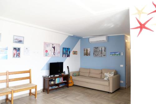 - un salon avec des murs bleus et un canapé dans l'établissement Casa Piano Ponente, à Isola delle Femmine