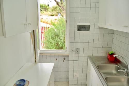 une cuisine avec un évier et une fenêtre dans l'établissement Appartamento BelMar, à Marina San Gregorio