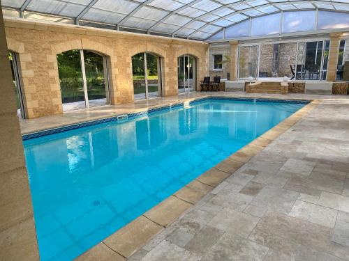 an indoor swimming pool with a glass ceiling at Villa & Spa dans le Périgord in Proissans