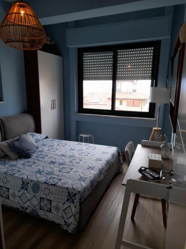 1 dormitorio con cama, mesa y ventana en IL VELIERO, en Scilla