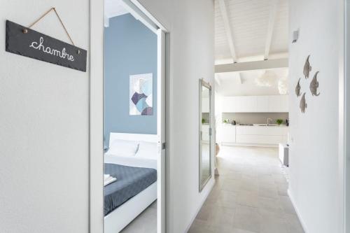 1 dormitorio con cama y puerta con espejo en Bianca - Marlù House -, en Cabras
