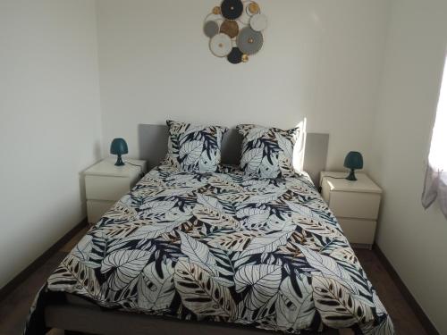 a bedroom with a bed with a comforter and pillows at Gîte entre terre et baie in Pontorson