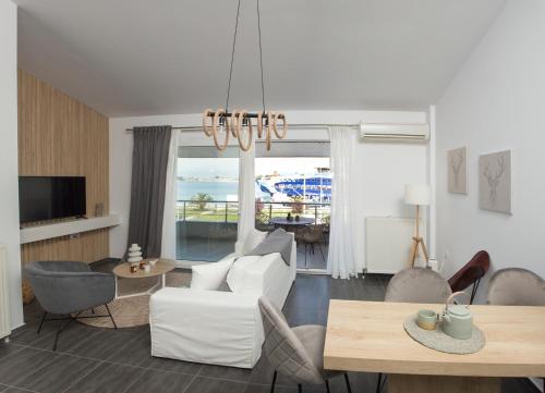a living room with white furniture and a view of the ocean at Sea View in Keramotí