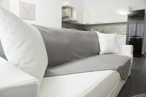 a white couch with pillows sitting in a kitchen at Sea View in Keramotí