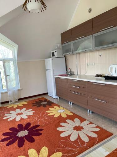 Гостевой дом в пансионате Солнышко, городок VIP-2 في Chok-Tal: مطبخ مع سجادة مطبخ على الأرض