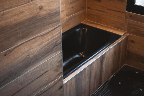 a kitchen with wood paneling and a black sink at Kombi By Carl-Emilie in Épinal